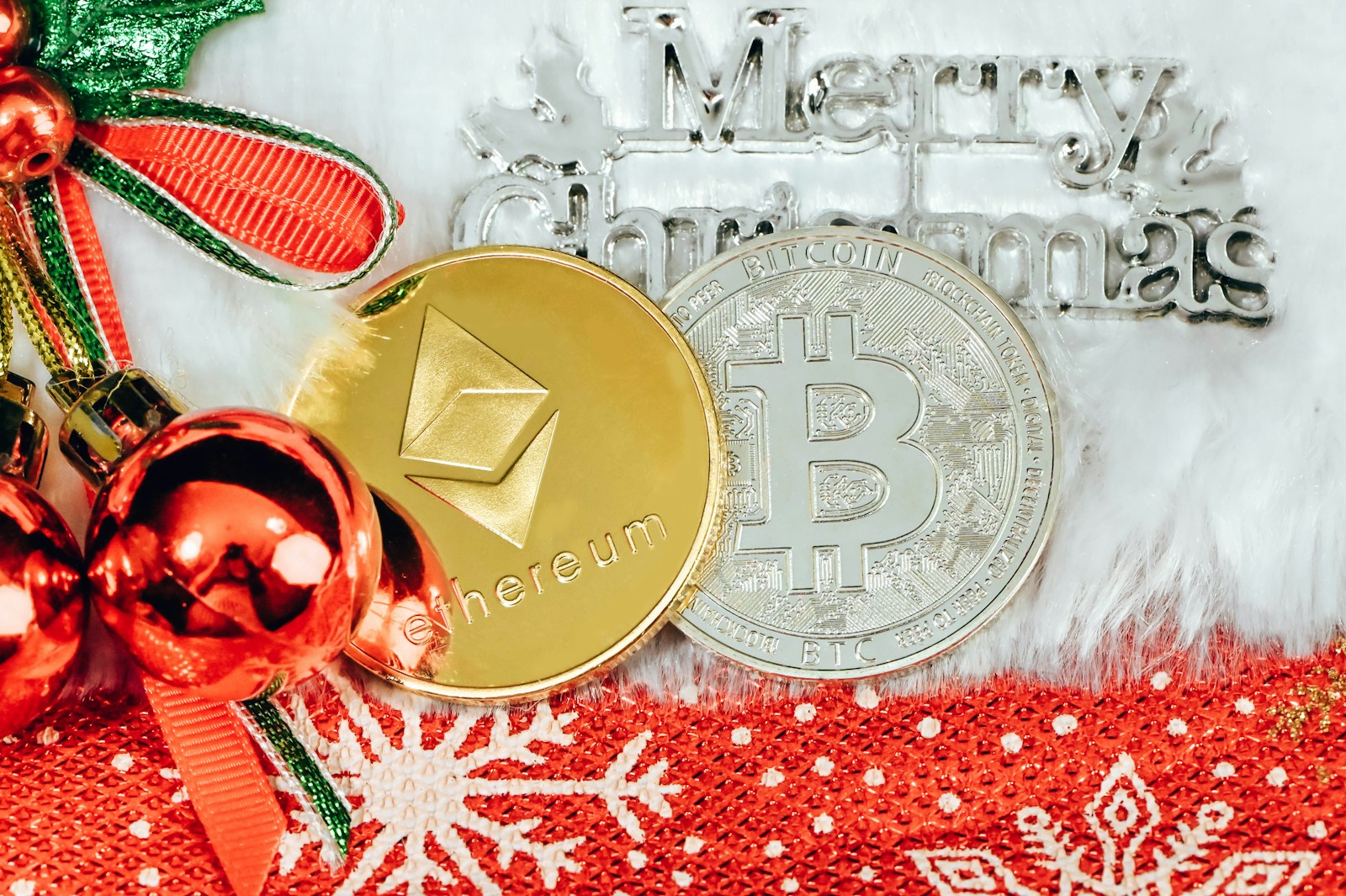 a bitcoin and christmas decorations on a red and white blanket , crypto